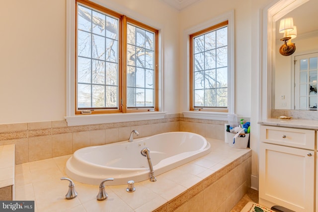 bathroom with tiled tub, vanity, a healthy amount of sunlight, and crown molding