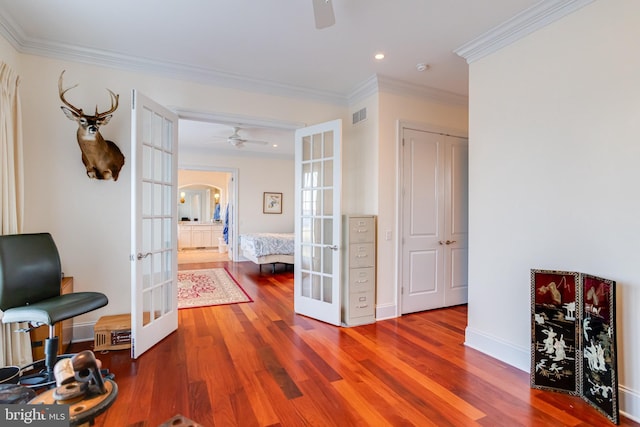 hall with wood-type flooring, ornamental molding, and french doors