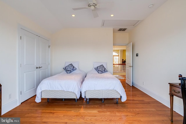 bedroom with ceiling fan, lofted ceiling, light hardwood / wood-style floors, and a closet