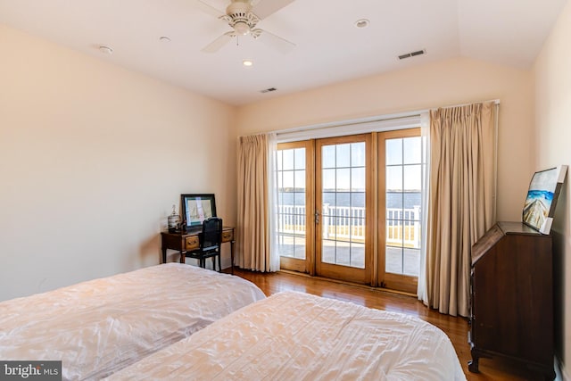 bedroom featuring a water view, ceiling fan, wood-type flooring, and access to exterior