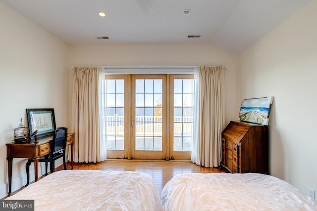 bedroom with multiple windows, lofted ceiling, access to outside, and light hardwood / wood-style floors