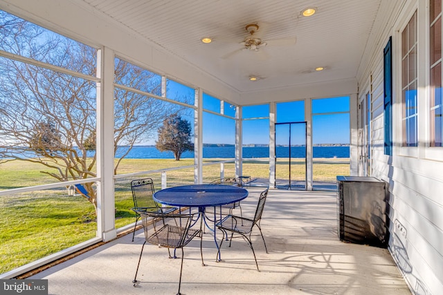 sunroom / solarium with a water view and ceiling fan