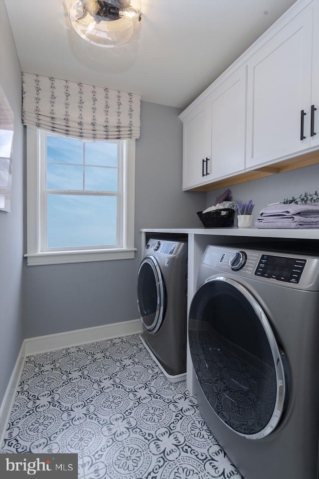 clothes washing area featuring cabinets, independent washer and dryer, and light tile floors