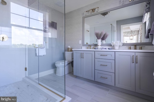 bathroom featuring toilet, tile flooring, dual vanity, and a shower with door