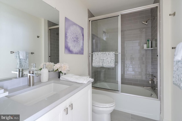 full bathroom featuring toilet, shower / bath combination with glass door, tile floors, and vanity