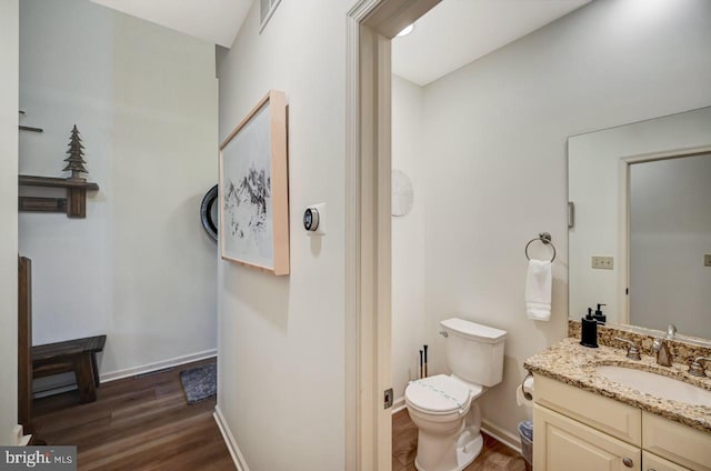 bathroom with hardwood / wood-style floors, toilet, and vanity