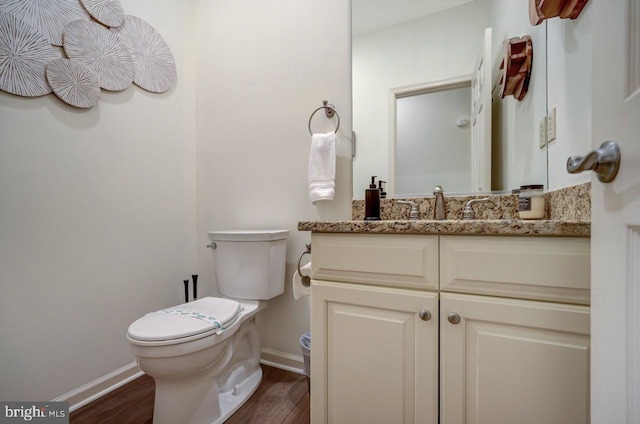 bathroom featuring wood-type flooring, vanity, and toilet