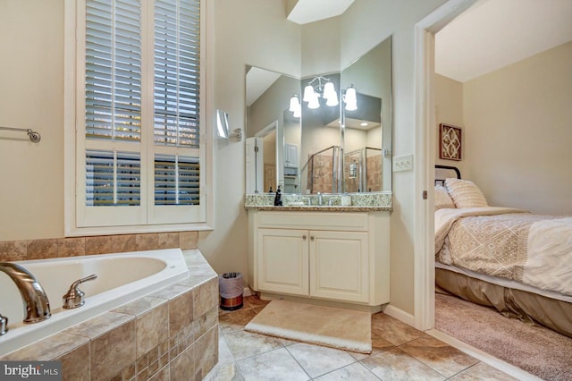 bathroom featuring tile floors, vanity with extensive cabinet space, and tiled tub