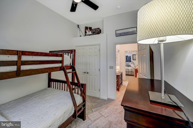 carpeted bedroom featuring ceiling fan and a closet