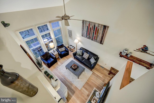 living room featuring high vaulted ceiling, ceiling fan, and hardwood / wood-style flooring