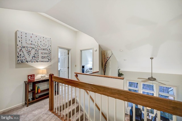 corridor featuring light colored carpet and vaulted ceiling