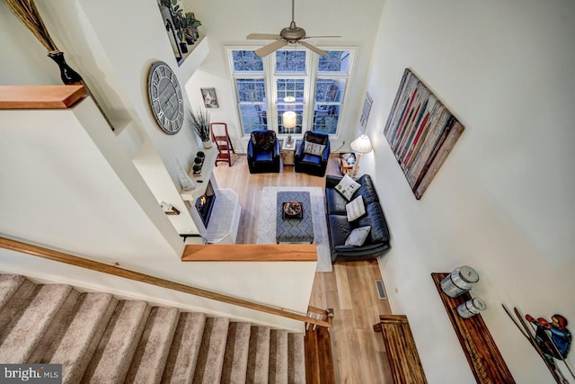 living room with a high ceiling, ceiling fan, and hardwood / wood-style floors