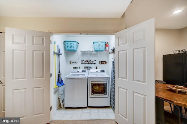 laundry room with light tile flooring, washing machine and dryer, hookup for a washing machine, and hookup for an electric dryer