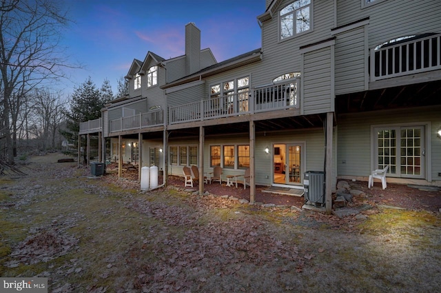 back house at dusk with a patio and central AC