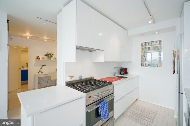 kitchen featuring track lighting, light hardwood / wood-style flooring, white cabinets, high end stove, and white refrigerator