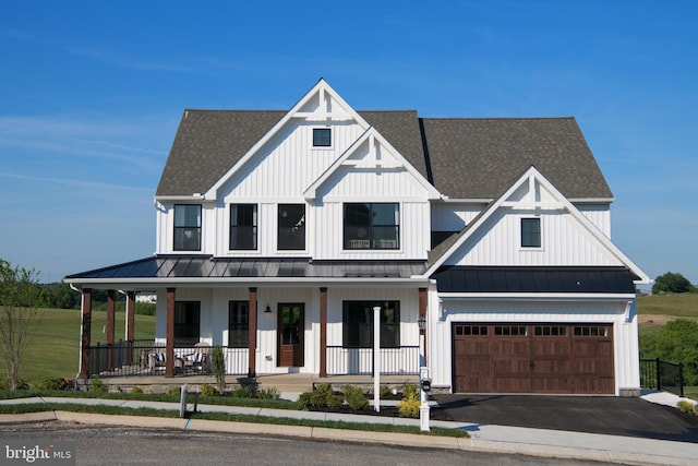 view of front facade with a porch, a front yard, and a garage