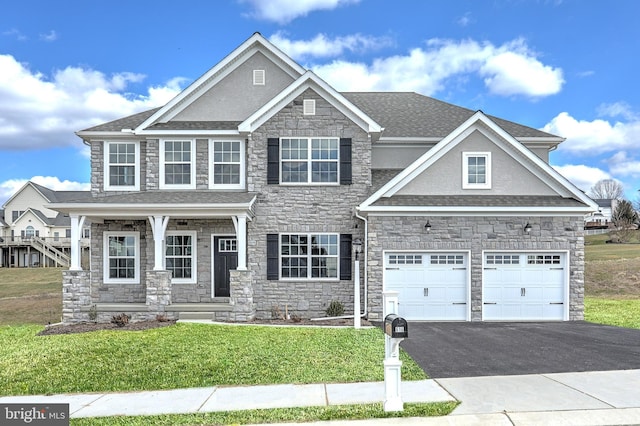 craftsman inspired home with a front lawn and a garage