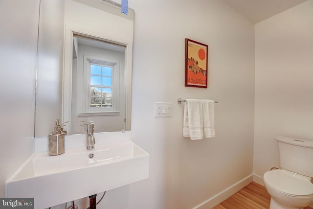 bathroom featuring toilet, hardwood / wood-style flooring, and sink