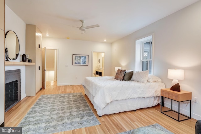 bedroom with ensuite bathroom, ceiling fan, and light hardwood / wood-style flooring