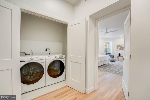 clothes washing area featuring electric dryer hookup, light hardwood / wood-style floors, ceiling fan, and independent washer and dryer