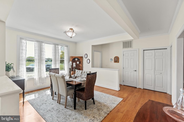 dining area with light hardwood / wood-style floors and crown molding