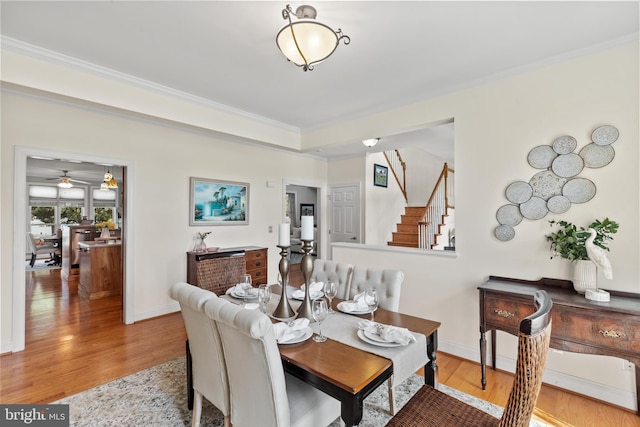 dining room featuring light hardwood / wood-style floors, ornamental molding, and ceiling fan