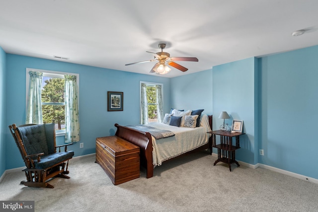 carpeted bedroom with ceiling fan and multiple windows