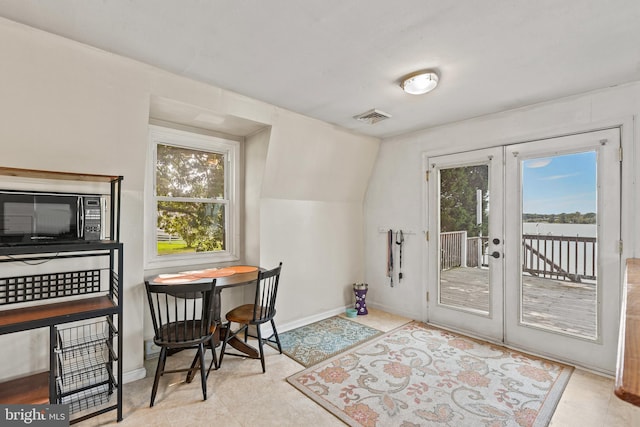 interior space featuring french doors, lofted ceiling, and light tile flooring