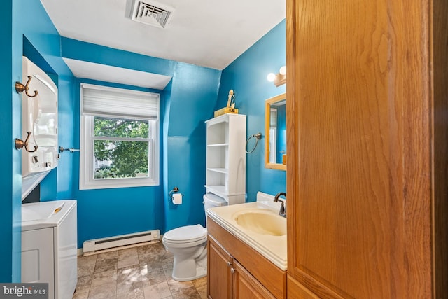 bathroom with tile flooring, stacked washer and dryer, a baseboard radiator, toilet, and vanity