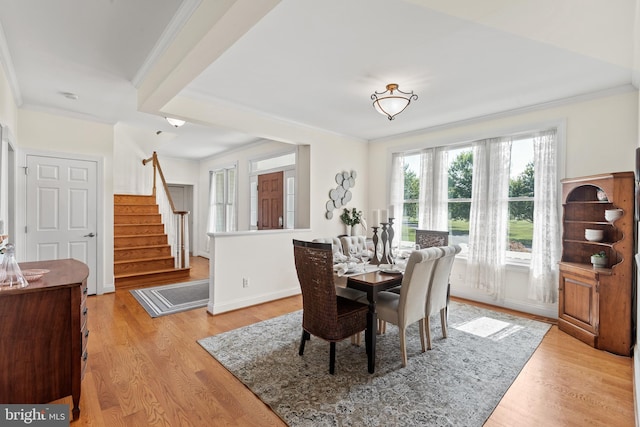 dining room featuring light hardwood / wood-style flooring and crown molding