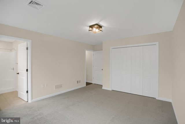 unfurnished bedroom with light carpet and a closet