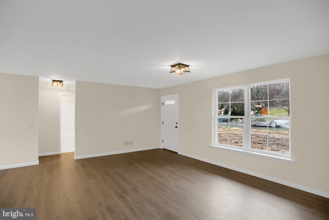 unfurnished room with dark wood-type flooring