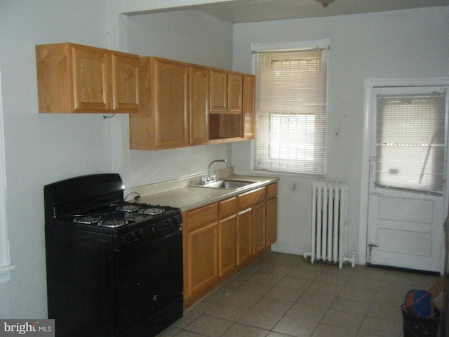 kitchen with light tile patterned flooring, sink, radiator heating unit, and black range with gas cooktop