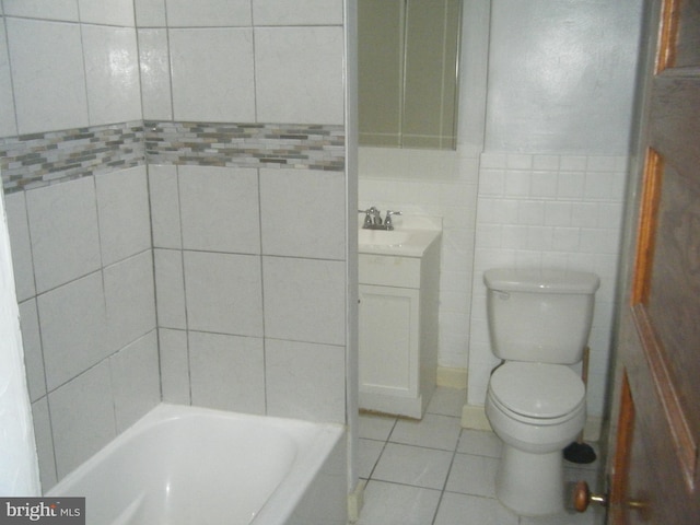 full bathroom with tile patterned flooring, washtub / shower combination, vanity, tile walls, and toilet