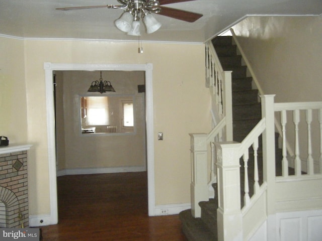 stairs featuring ceiling fan, ornamental molding, and hardwood / wood-style floors