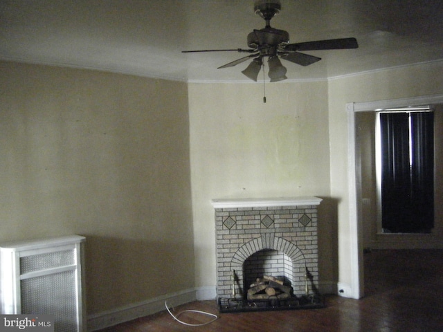 unfurnished living room featuring ceiling fan and a brick fireplace