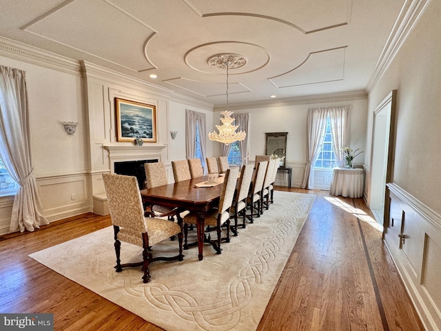 dining space with an inviting chandelier, crown molding, and light hardwood / wood-style floors