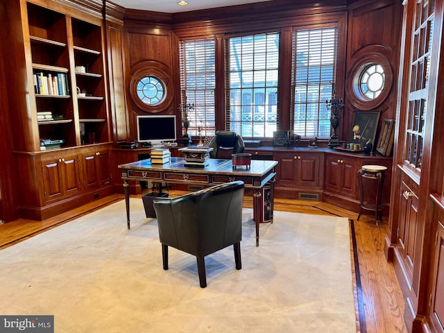 home office featuring light hardwood / wood-style floors and wooden walls