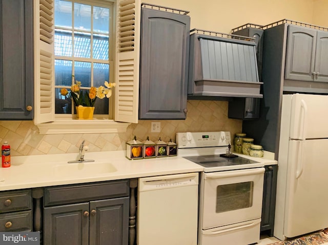 kitchen with gray cabinetry, tasteful backsplash, white appliances, sink, and exhaust hood