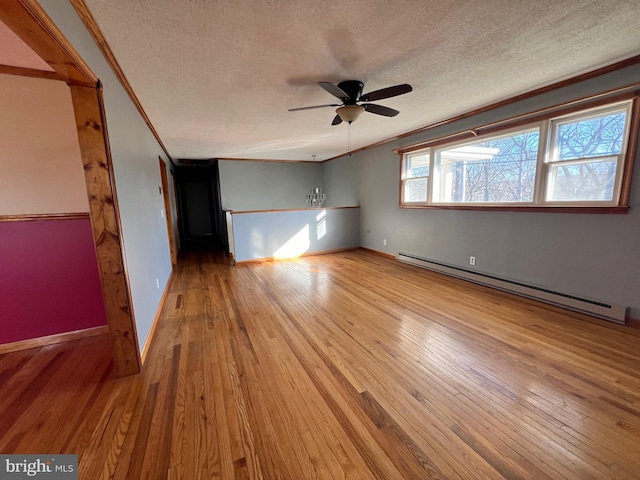 spare room featuring light hardwood / wood-style flooring, ceiling fan, a baseboard radiator, and ornamental molding