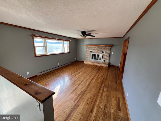 unfurnished living room with ceiling fan, a baseboard radiator, a brick fireplace, a textured ceiling, and hardwood / wood-style flooring