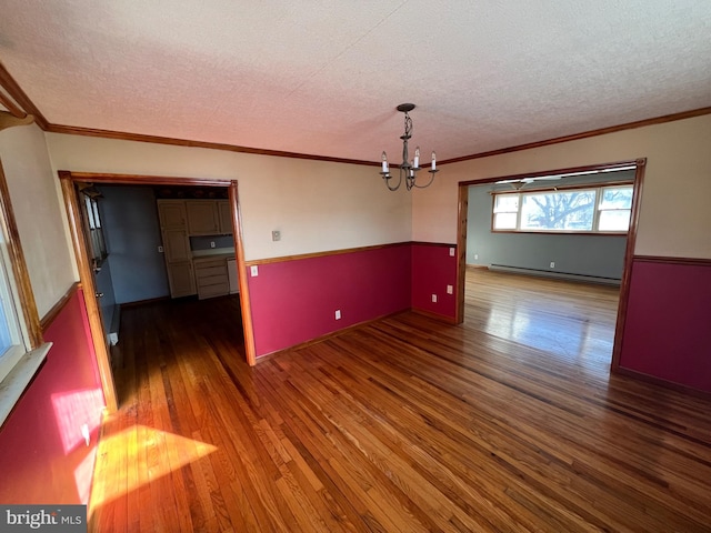 empty room with a chandelier, a baseboard radiator, dark wood-type flooring, and a textured ceiling