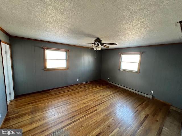 empty room with hardwood / wood-style floors, a textured ceiling, ceiling fan, and a baseboard radiator