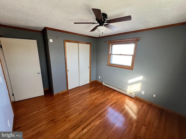 unfurnished bedroom with hardwood / wood-style floors, ceiling fan, a baseboard radiator, a textured ceiling, and ornamental molding