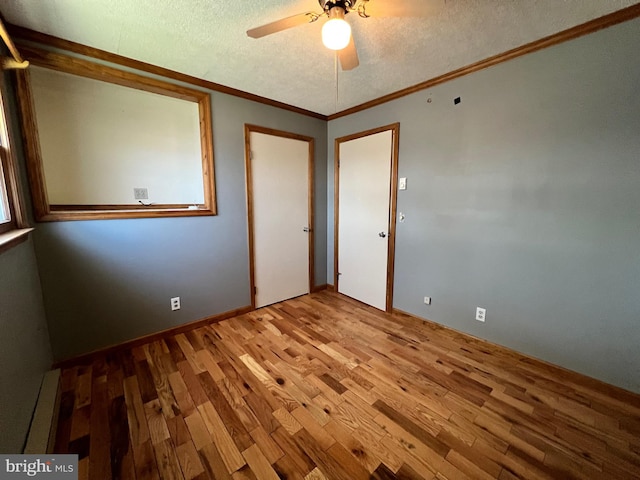 unfurnished room featuring ceiling fan, light hardwood / wood-style floors, a textured ceiling, a baseboard heating unit, and ornamental molding