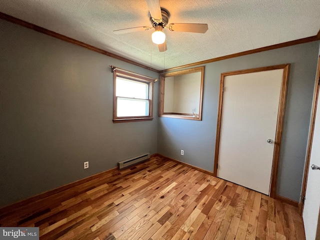 spare room featuring a baseboard radiator, a textured ceiling, ceiling fan, and light wood-type flooring