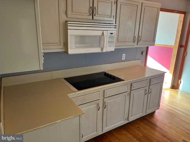 kitchen with black electric stovetop and wood-type flooring