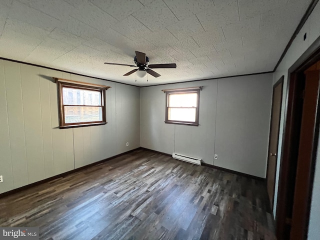 unfurnished room featuring ceiling fan, baseboard heating, and dark hardwood / wood-style floors