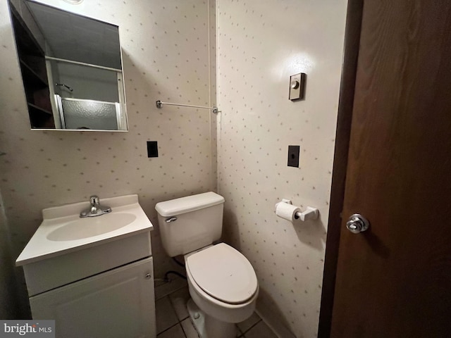 bathroom featuring toilet, large vanity, and tile floors