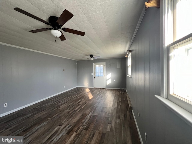 empty room with ornamental molding, ceiling fan, and dark hardwood / wood-style flooring